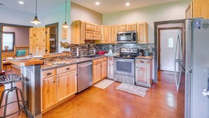 A modern kitchen with wooden cabinets, stainless steel appliances, and a central island. - Boaters Base! 11 Mi to Kentucky & Barkley Lakes (Grand Rivers)