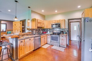 A modern kitchen with wooden cabinets, stainless steel appliances, and a central island. - Boaters Base! 11 Mi to Kentucky & Barkley Lakes (Grand Rivers)
