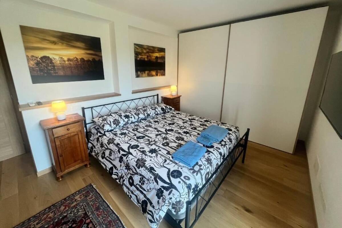 Ein Schlafzimmer mit einem Bett, Nachttischen, einem Teppich und zwei an der Wand befestigten Bildern.