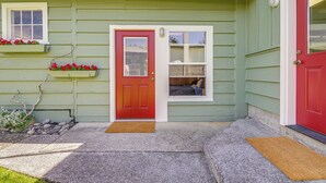 A house with a red door, a window with a view, and a small porch area. - Beachfront Oasis! Lummi Island Family Getaway (Lummi Island)