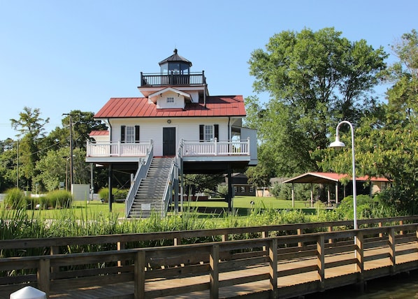 A two-story building with a red roof, a balcony, and a staircase leading to the upper level.