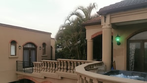 Un bâtiment doté d’un balcon, d’un jacuzzi et d’un palmier.