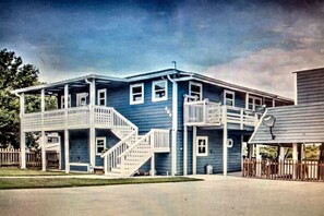 A two-story building with a balcony and a staircase.