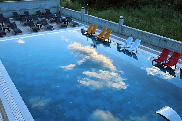 Una piscina al aire libre, tumbonas