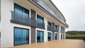 Un edificio moderno con ventanas amplias, balcones y techo plano.