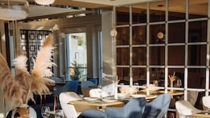 Een restaurant interieur met ronde tafels, blauwe stoelen en een modern design.