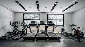 Een sportschool met loopbanden, elliptische trainers en een roeimachine.