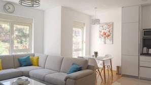 Een moderne woonkamer met een bank, salontafel en een eethoek.