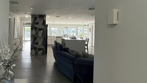 A modern living room with a sofa, a dining area with a table and chairs, and a kitchen in the background. - A 2B/2B Hidden Waterfront Gem in St James City! (St James City)