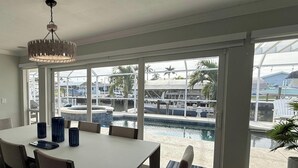 A dining area with a view of a marina and pool. - A 2B/2B Hidden Waterfront Gem in St James City! (St James City)