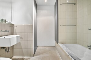 Ein modernes Badezimmer mit Waschbecken, Spiegel, Dusche und Badewanne.