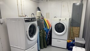 A laundry room with two stacked washers and dryers, a water tank, and various cleaning supplies. - The Gulf Oasis-
 Pool, hot tub, boat ramp, floating dock, kayaks, waterfront (Hudson)