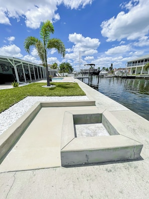 A waterfront property with a swimming pool, a covered outdoor area, and a dock. - The Gulf Oasis-
 Pool, hot tub, boat ramp, floating dock, kayaks, waterfront (Hudson)