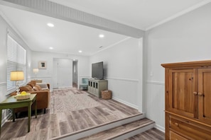 A living room with a sofa, TV, and wooden cabinet. - The Paddle House 3/2 Walking Distance To New Pickleball Courts (Dothan)