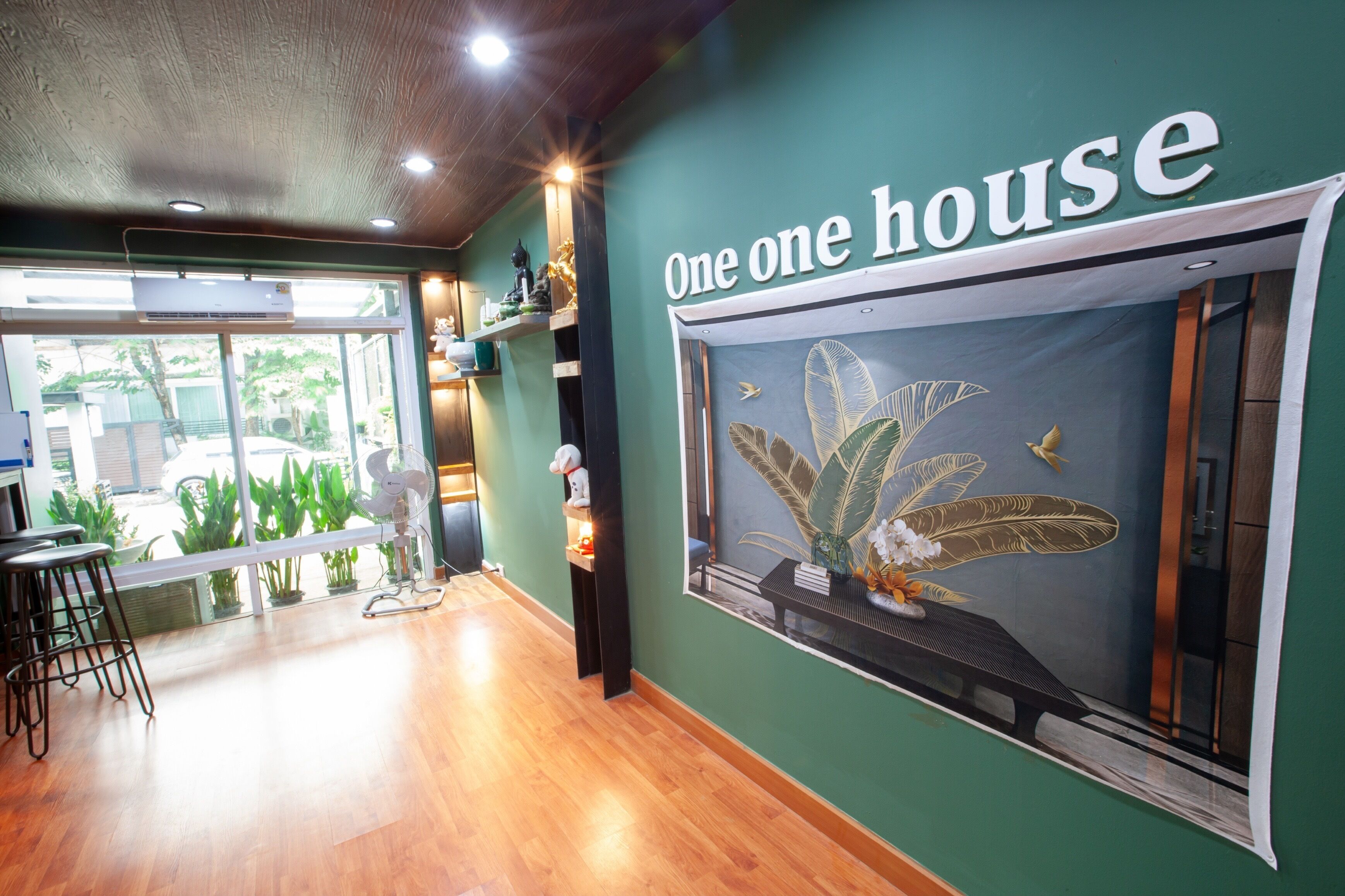 Ein Zimmer mit einem Schild 'One one house', Holzboden, einem Fenster mit Blick und einer Bar mit Hockern.