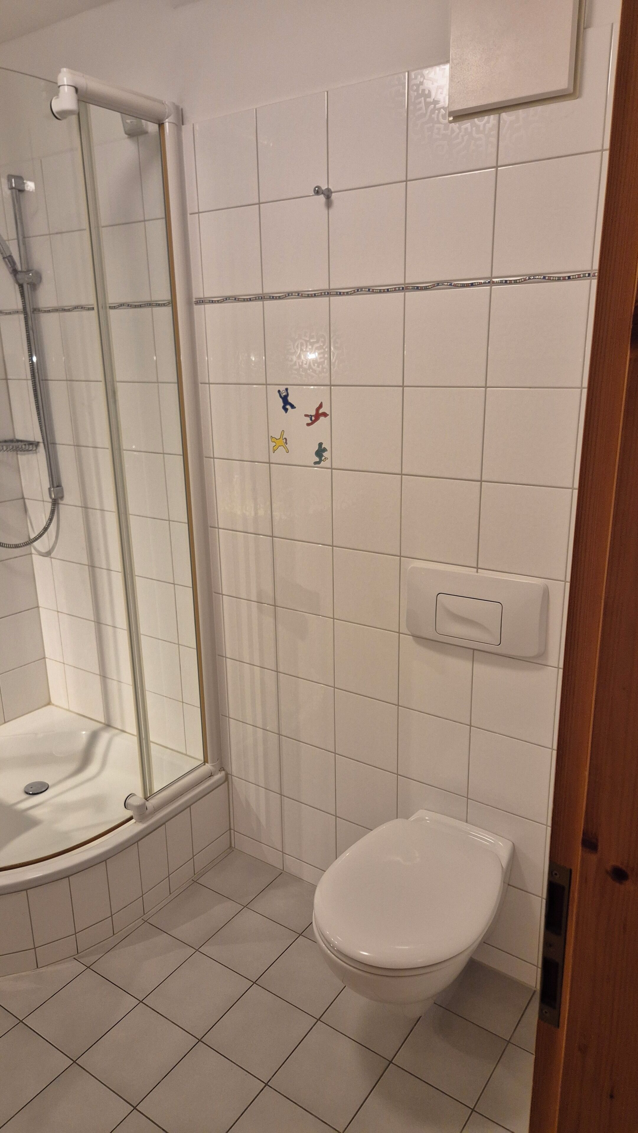 A bathroom with a shower, toilet, and sink.