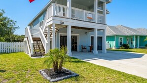 A two-story house with a balcony, a flag, and a small garden. - Lone Star Lookout | Pet-Friendly + Community Pool! (Rockport)