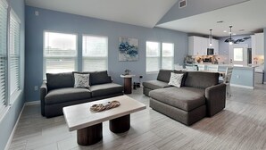 A modern living room with a sofa set, a coffee table, and a kitchen in the background. - Lone Star Lookout | Pet-Friendly + Community Pool! (Rockport)
