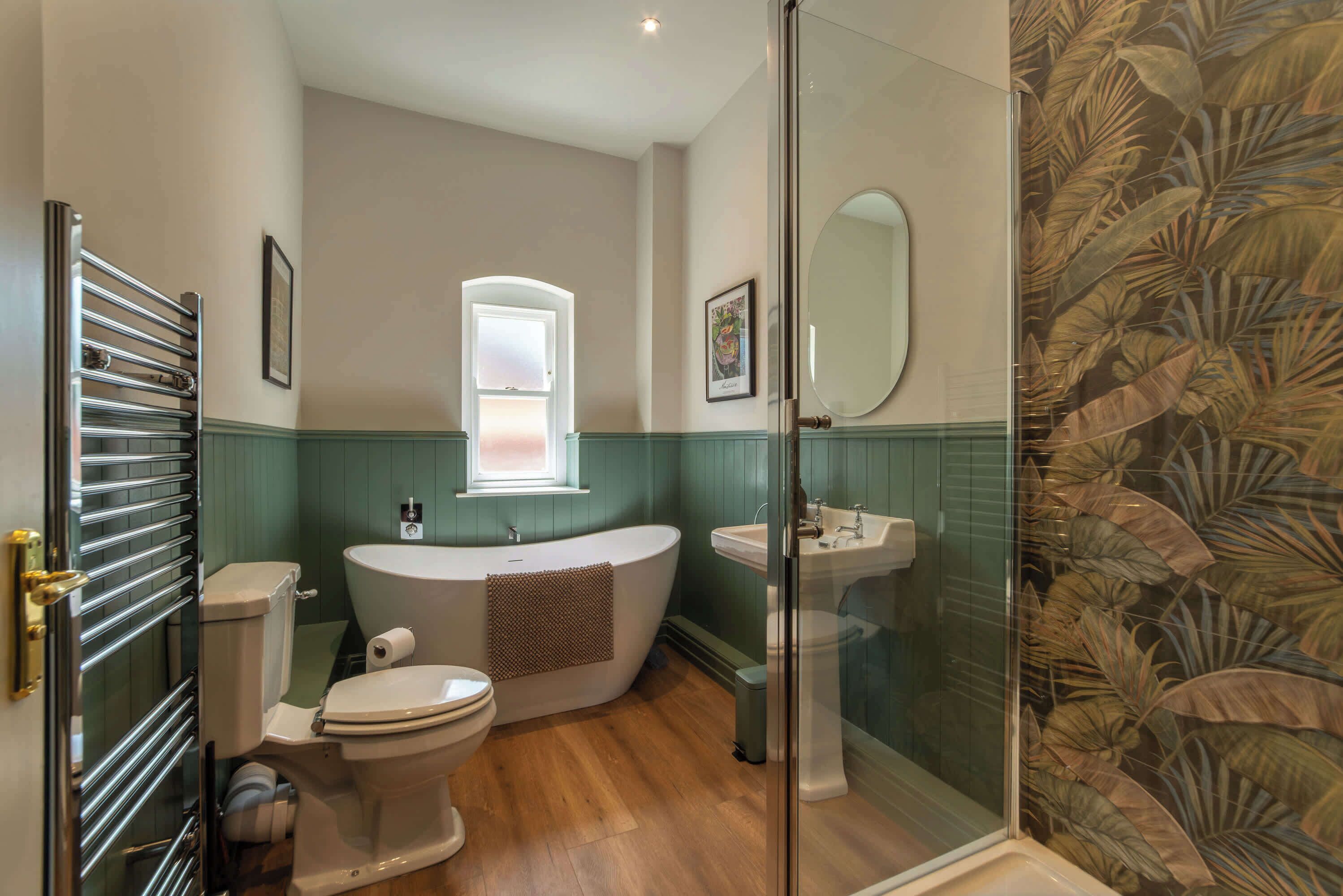 A bathroom with a toilet, bathtub, and glass-enclosed shower.