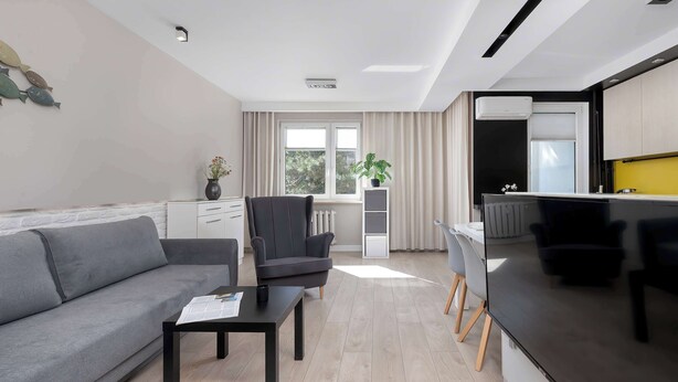 Ein modernes Wohnzimmer mit einer Couch, einem Couchtisch und einem Flachbildfernseher.