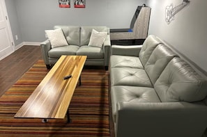 Ein Wohnzimmer mit einer Couch, einem Couchtisch und einem Fernseher.