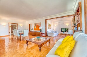 A spacious living area with a dining table, sofa, and TV. - House with pool Can Quiros Can Picafort (Can Picafort)