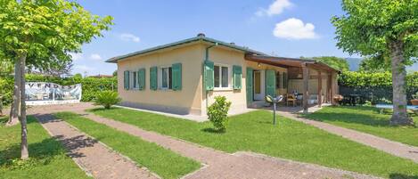 A single-story building with a flat roof, a paved driveway, and a small lawn area.