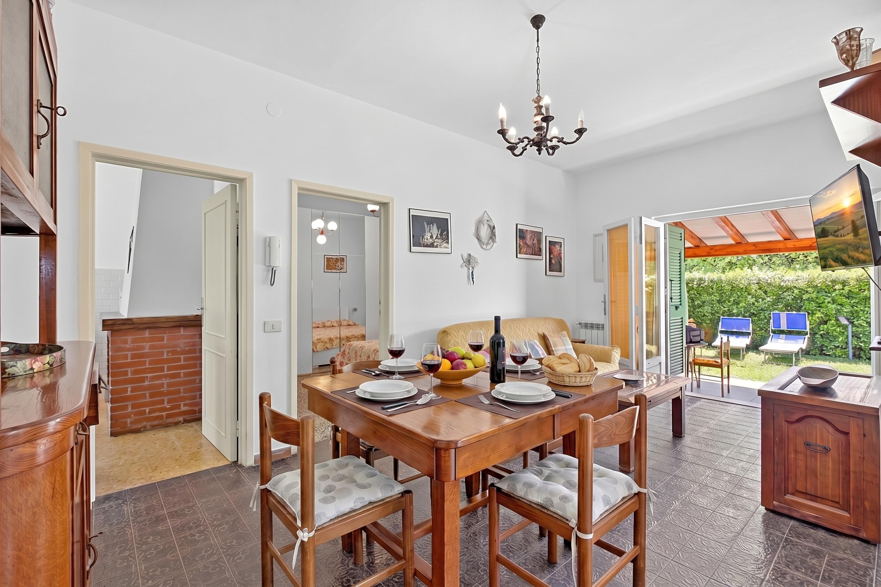 A dining area with a wooden table, chairs, and a chandelier.