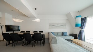 A modern hotel room with a dining area, a sofa, a TV, and a large window with curtains. - HOTEL LEGALIE Osaka Shinsaibashi North (Osaka)