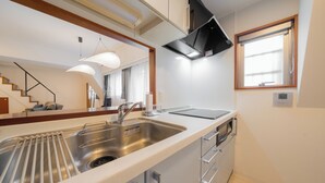 A modern kitchen with a stainless steel sink, a built-in oven, and a window with a view. - HOTEL LEGALIE Osaka Shinsaibashi North (Osaka)