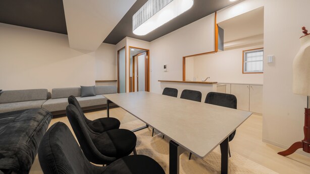 A modern meeting room with a long table, black chairs, a grey sofa, and a wooden cabinet. - HOTEL LEGALIE Osaka Shinsaibashi North (Osaka)