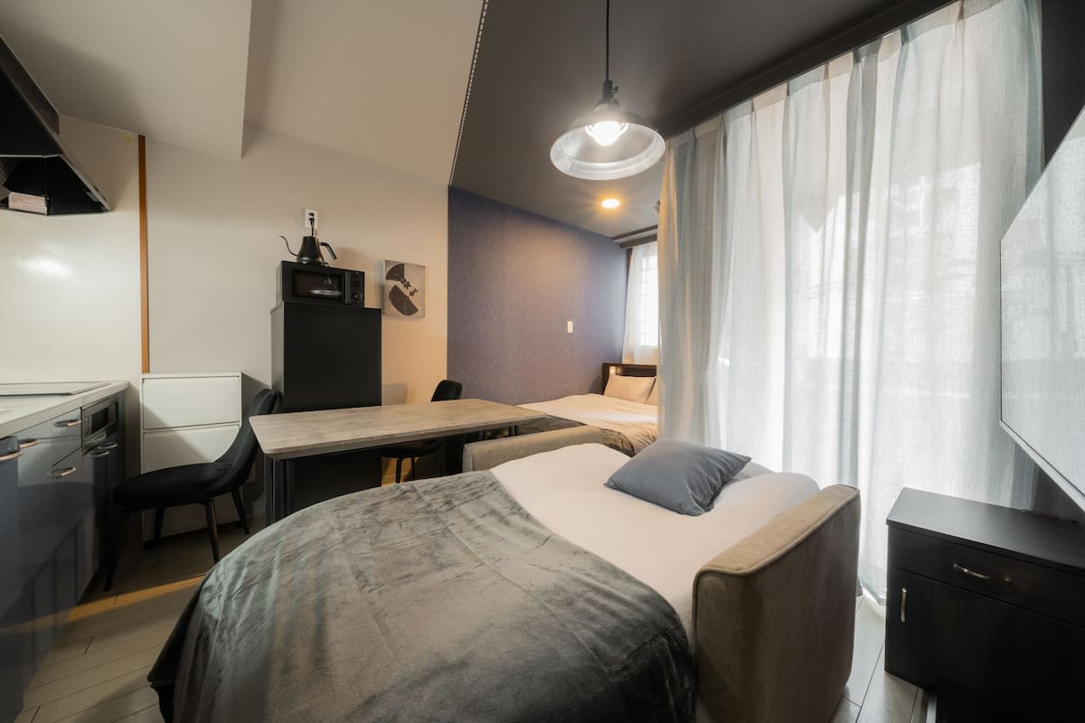 Habitación de hotel moderna con cama, escritorio, silla y televisor.