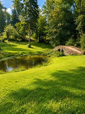 A stone bridge over a pond in a lush green park. - Sea-view house in an exceptional private estate (Douarnenez)