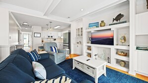 Uma sala de estar moderna com sofá, mesa de centro e objetos decorativos nas prateleiras.