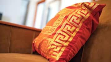 Un canapé marron agrémenté d’un seul coussin décoratif orné d’un motif géométrique.