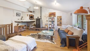 Uma sala de estar aconchegante com lareira, estantes de livros, um sofá e um tapete com padrão de zebra.