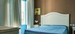 A bedroom with a bed, a nightstand, a lamp, a window with curtains, and a wall-mounted picture. - Borgo Rio Favara 6 - Moon (Ispica)