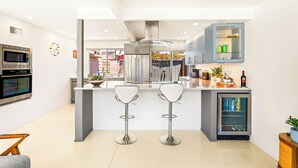 Eine moderne Küche mit Kochinsel, Edelstahlgeräten und einem eingebauten Kühlschrank.