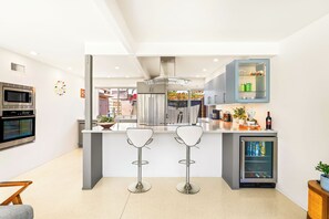 Eine moderne Küche mit Kochinsel, Edelstahlgeräten und einem eingebauten Kühlschrank.