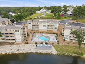 Ein mehrstöckiges Hotel mit Schwimmbad, Sitzgelegenheiten im Freien und Blick auf die Umgebung.