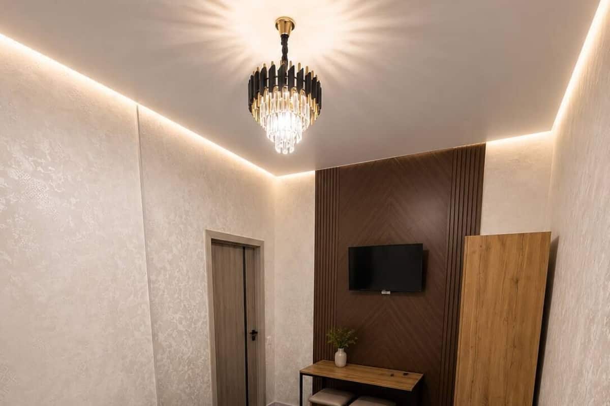 Une chambre dâhĂŽtel Ă©quipĂ©e dâun lit, dâun bureau, dâune chaise, dâune tĂ©lĂ©vision et dâun mur recouvert de panneaux de bois.