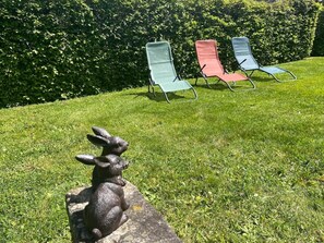 A grassy area with three lawn chairs and a stone sculpture of a rabbit. - La Maison d'Odette: the Hortensia room (Saint-Rémy-du-Plain)