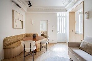 A modern living room with a round dining table, a sofa, and a coffee table. - Neuf Cœur Paris 1-Bedroom Arts et Métiers Marais#AC (Paris)