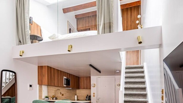 Un interior moderno con cocina, comedor y escalera.