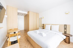 Ein modernes Hotelzimmer mit einem Bett, einem kleinen runden Tisch und einem Stuhl.