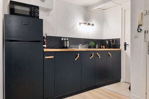 Una cocina con gabinetes negros, un microondas y una lámpara.