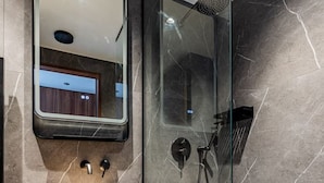 A modern bathroom with a wooden vanity, a large mirror, a glass-enclosed shower, and marble walls. - 151. Luxury suite-Etienne Marcel-Châtelet-Paris 3 (Paris)