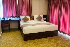 A hotel room with a bed, a desk, and curtains. - Collection O Kengeri Bus Terminal (Bengaluru)