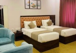 A hotel room with two beds, a nightstand, a chair, and a wall-mounted artwork. - Collection O Kengeri Bus Terminal (Bengaluru)
