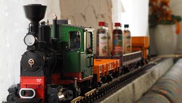 A model train with a green locomotive and orange cars on a track.